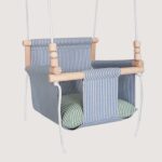 Linen baby swing with green striped pillows
